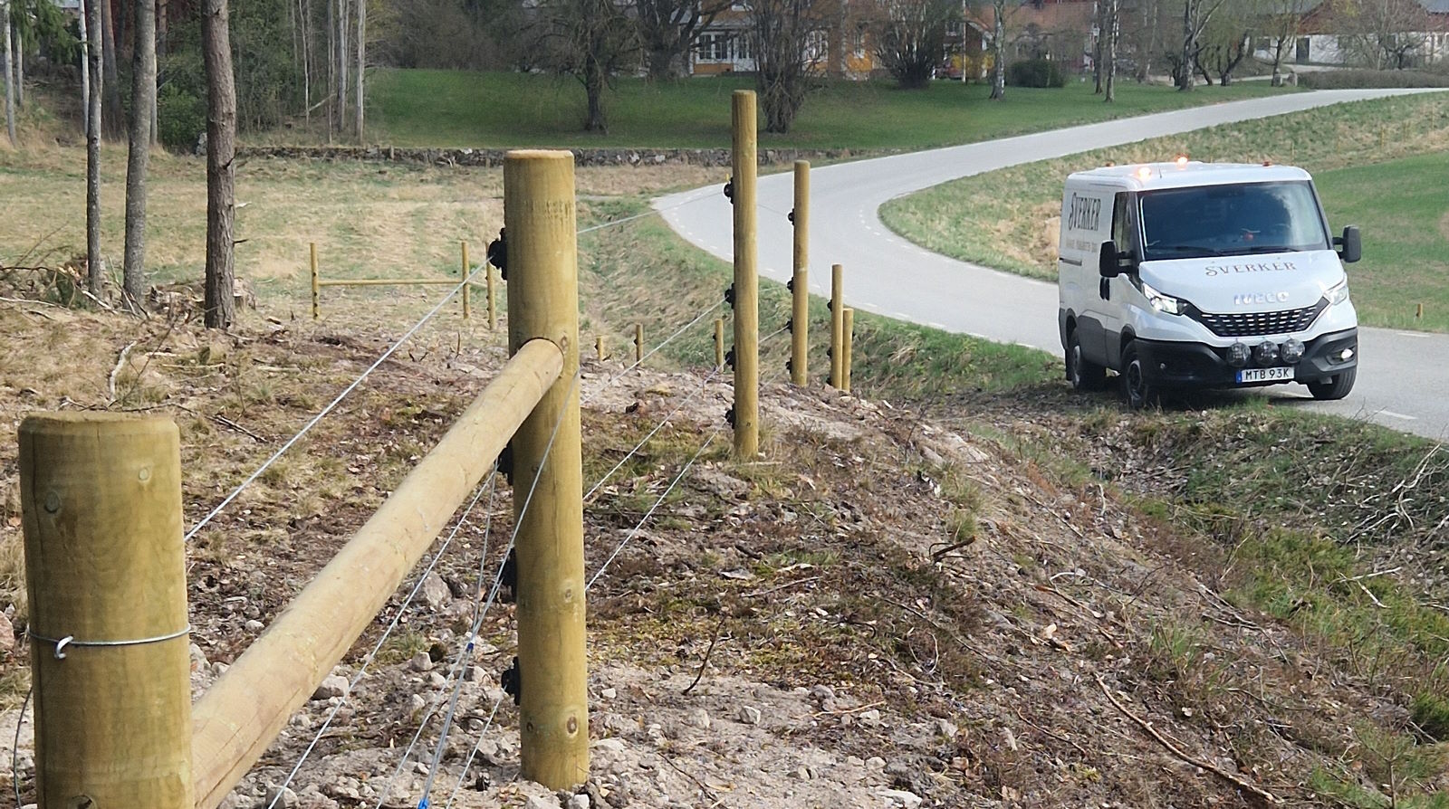 Nybyggt stängsel längs en grusväg